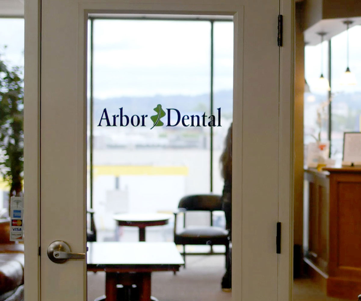 An interior view of a dental office entrance with an  Arbor Dental  sign above the door.