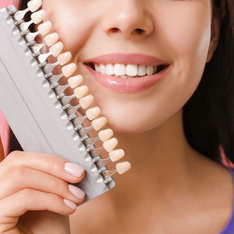 The image shows a woman holding a dental floss dispenser with multiple strands of floss, smiling at the camera.