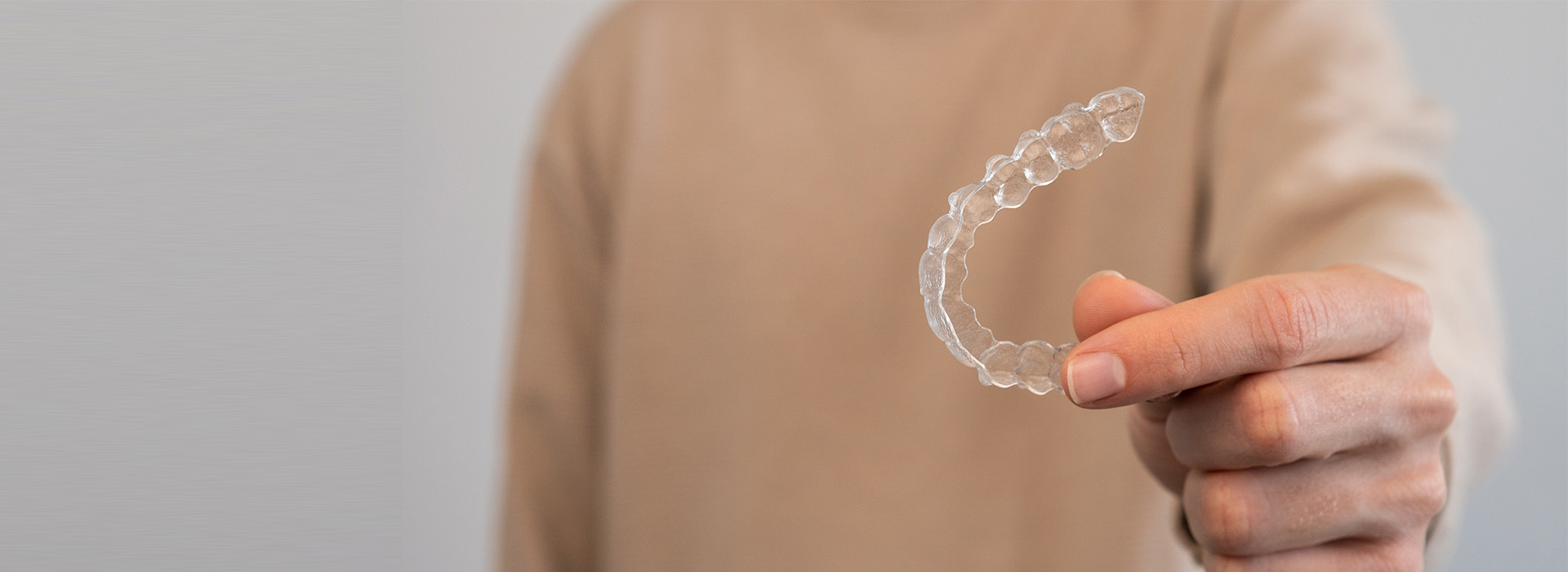 The image shows a person s hand holding an object that resembles a soap bubble, with the background blurred.