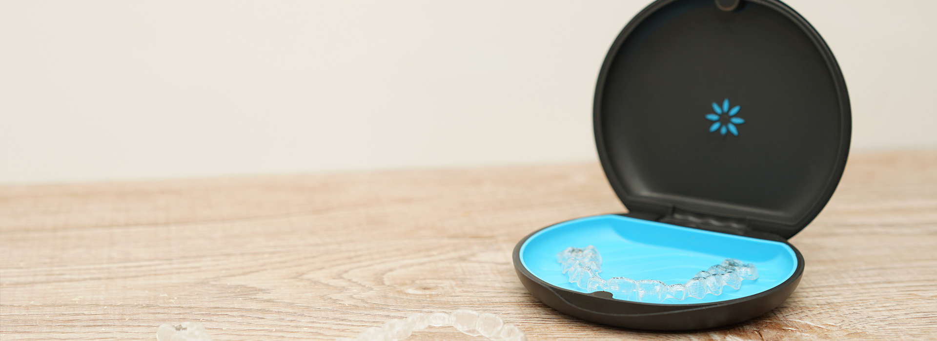 This is an image featuring a smart home device, specifically a Wi-Fi router, with its antennas visible and placed on a flat surface against a backdrop of a plain wall.