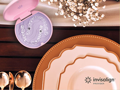 The image shows a collection of tableware including plates, bowls, and a spoon, arranged on a wooden surface with a pink box of dental floss nearby.