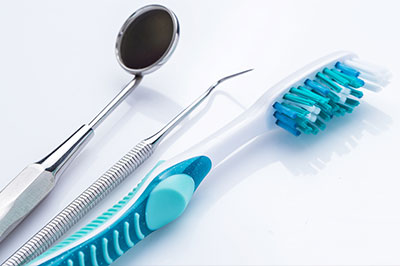 A dental hygiene set displayed on a white background with various tools for cleaning teeth.